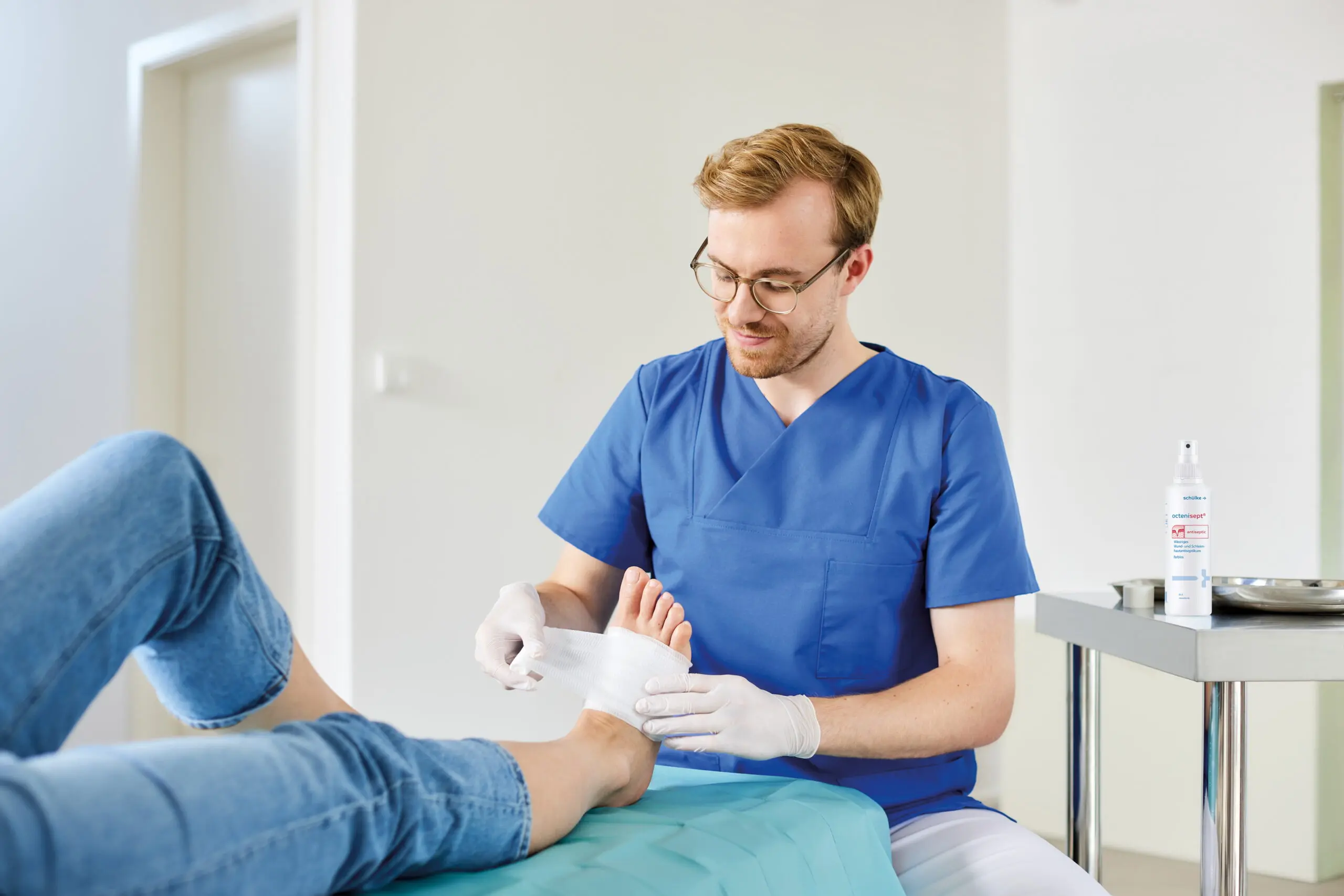 Medizinisches Fachpersonal tupft eine chronische Wunde bei einem Patienten ab.