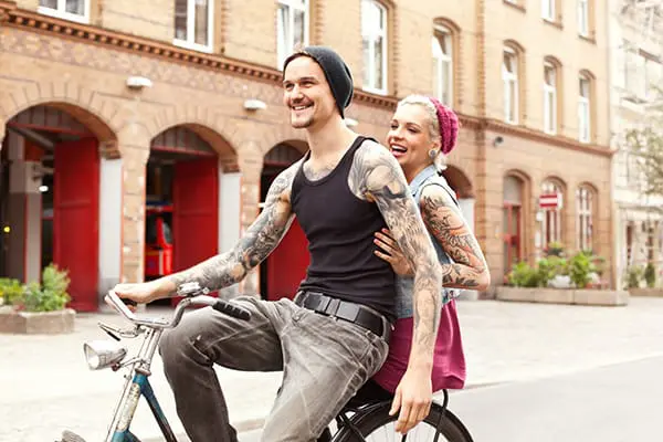 Ein frisch tätowiertes Pärchen fährt Fahrrad.
